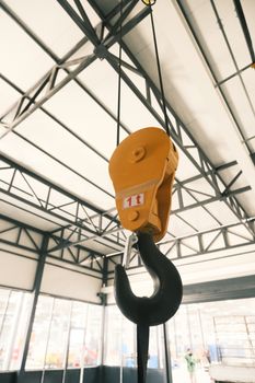 Yellow industrial crane hook inside a warehouse in Konya, Türkiye.