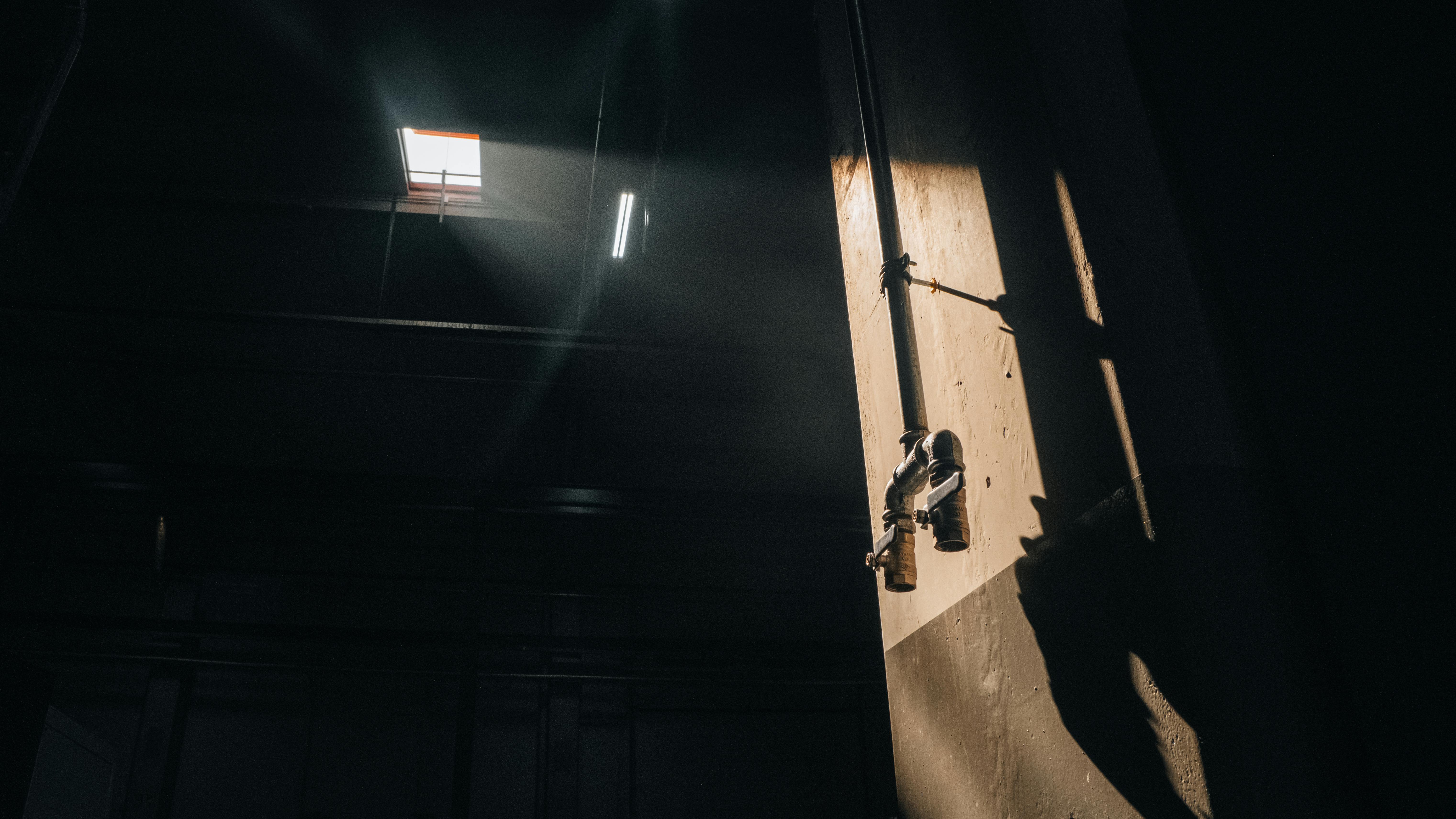 Free Dramatic lighting on industrial pipes casting shadows indoors, evoking a cinematic feel. Stock Photo