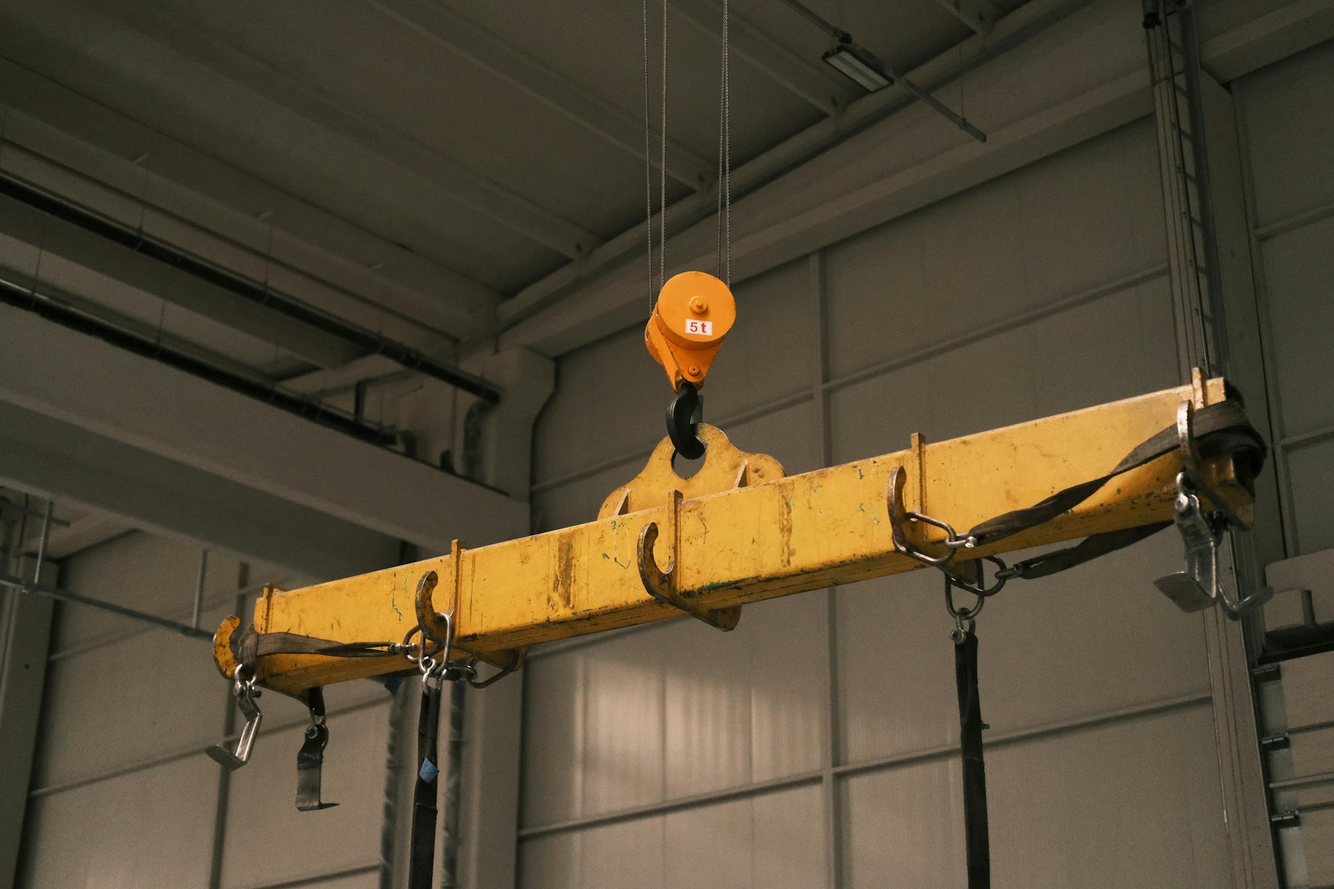 Close-up of a yellow industrial crane used in manufacturing, highlighting strength and machinery.
