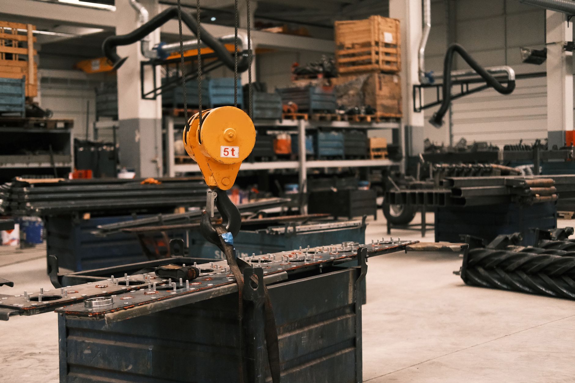 Close-up of a yellow industrial crane hook in a manufacturing workshop in Konya, Türkiye, showcasing metalwork.