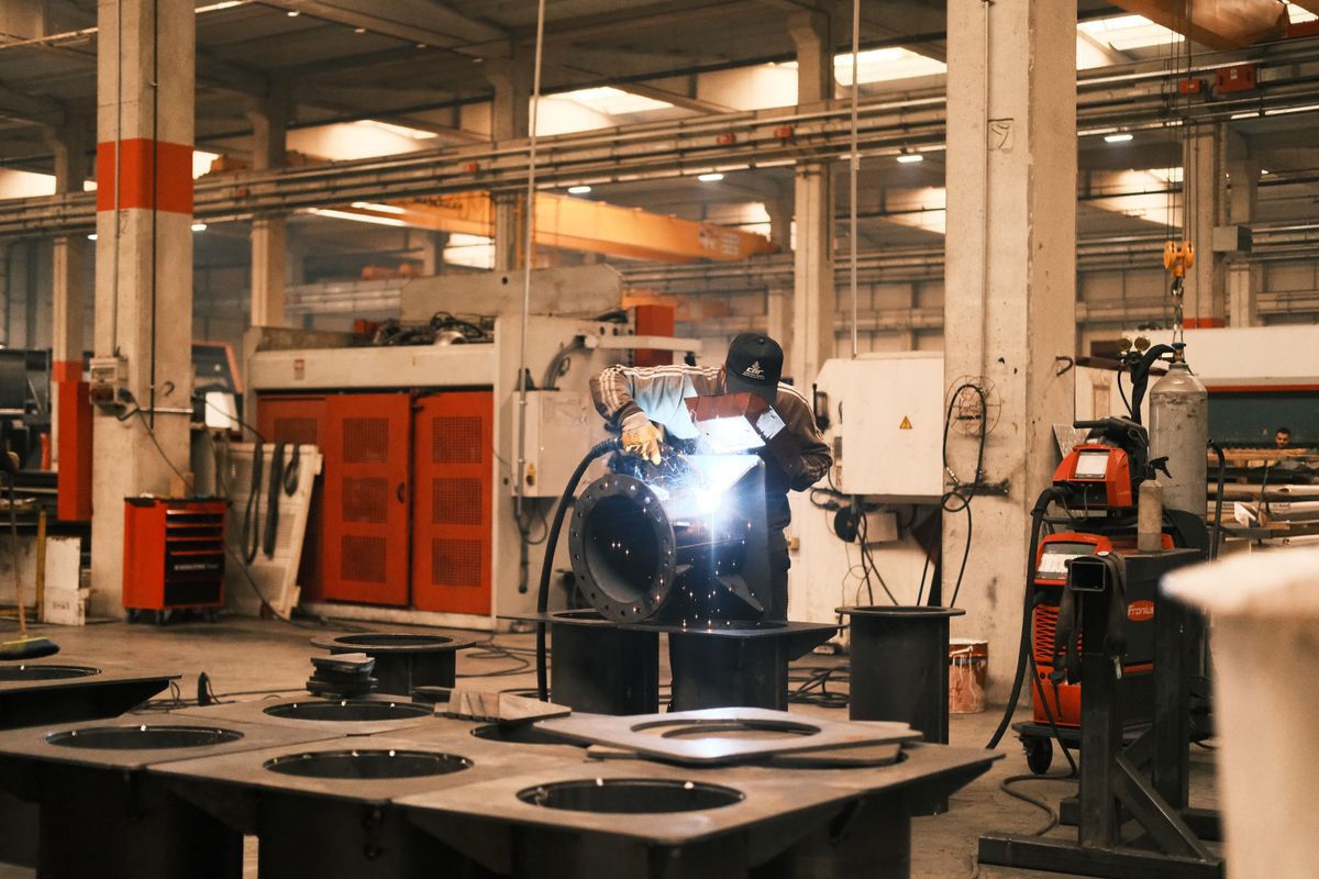 Welder working in an industrial weld shop with sparks