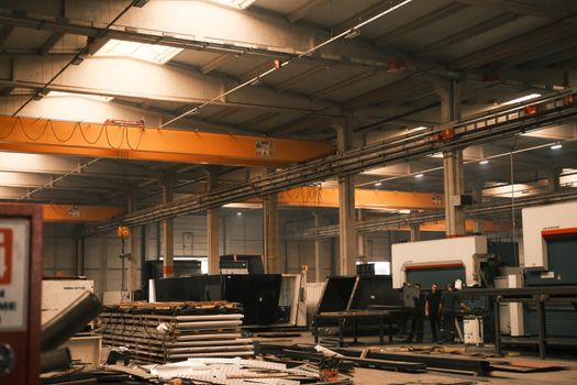 Interior view of an industrial warehouse with machinery and overhead cranes in Konya, Türkiye.