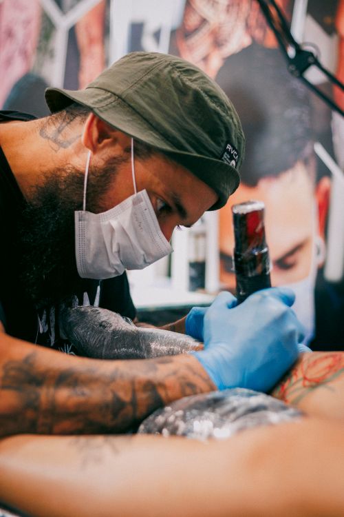 Free A skilled tattoo artist carefully designs a tattoo on a client's arm in a studio. Stock Photo