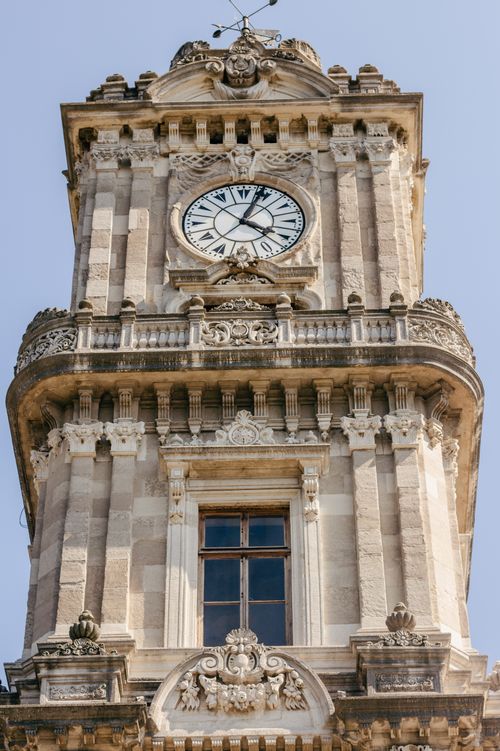 Free Close-up of a historical clock tower with ornate architectural details under a clear blue sky. Stock Photo