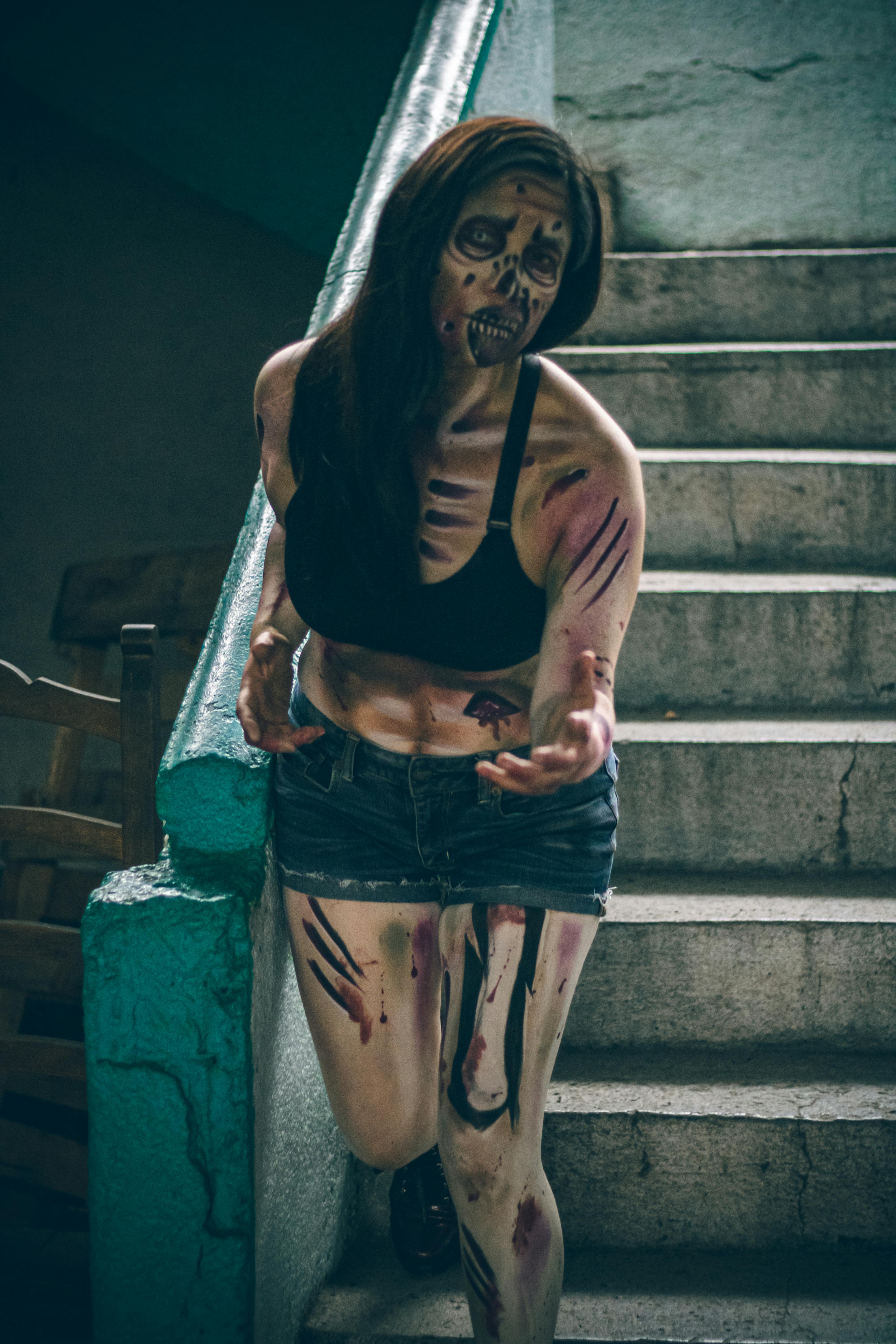 Female in zombie makeup on stairs, Ciudad de México, eerie atmosphere.