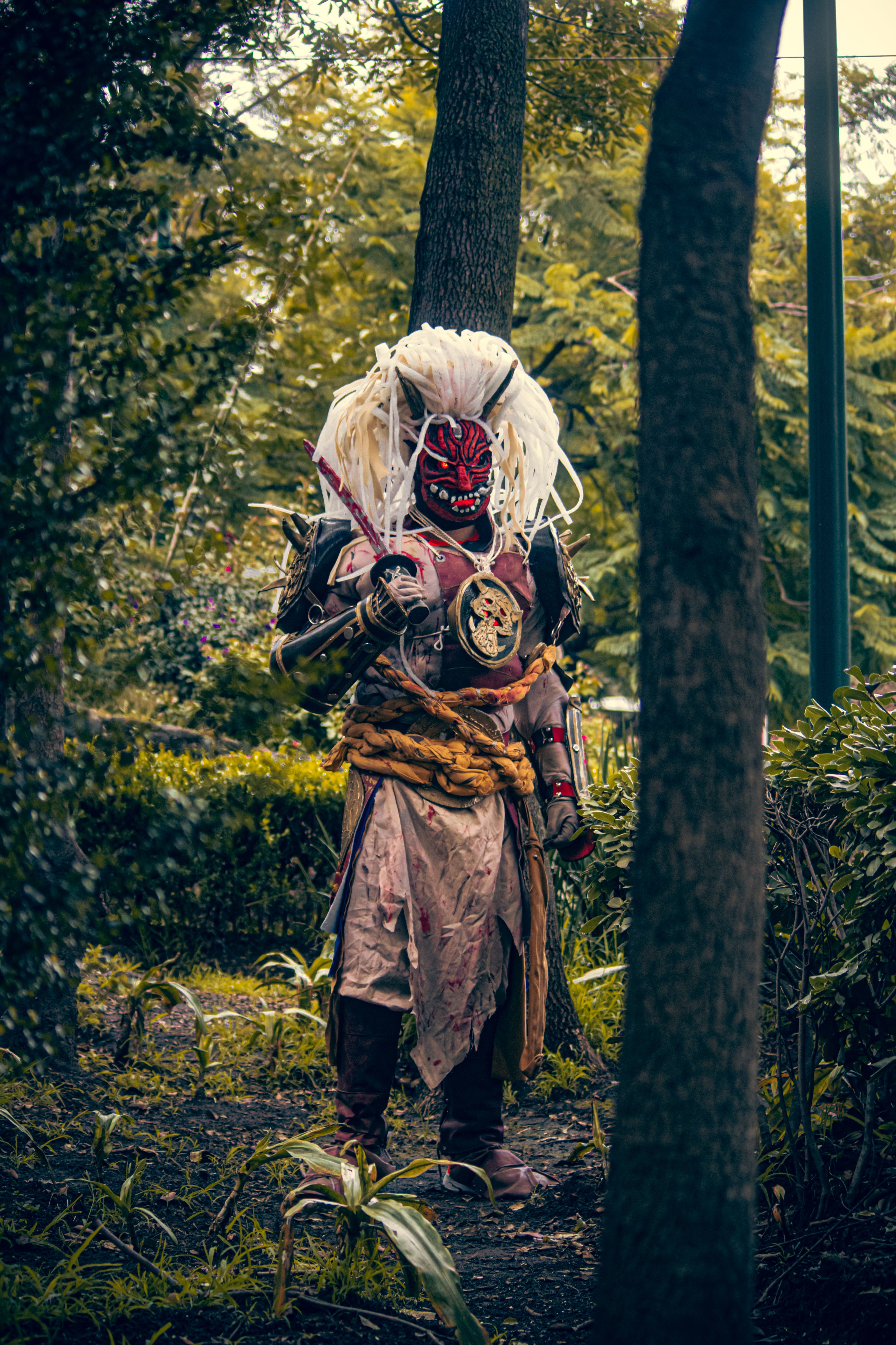 A striking demonic samurai costume captured in a lush urban park in Mexico City.
