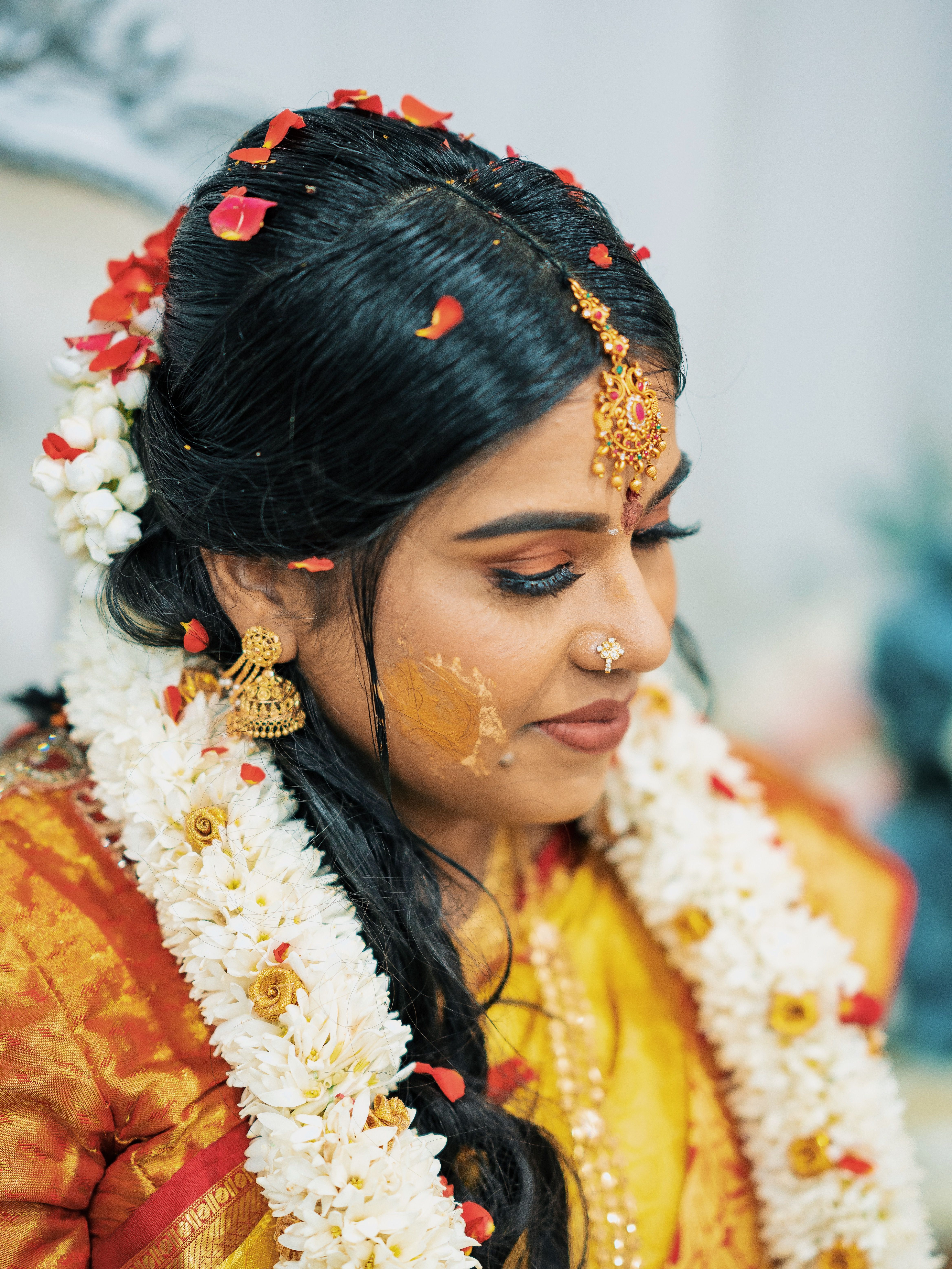 Beautiful portrait of a bride in traditional attire, adorned with floral garlands and jewelry.
