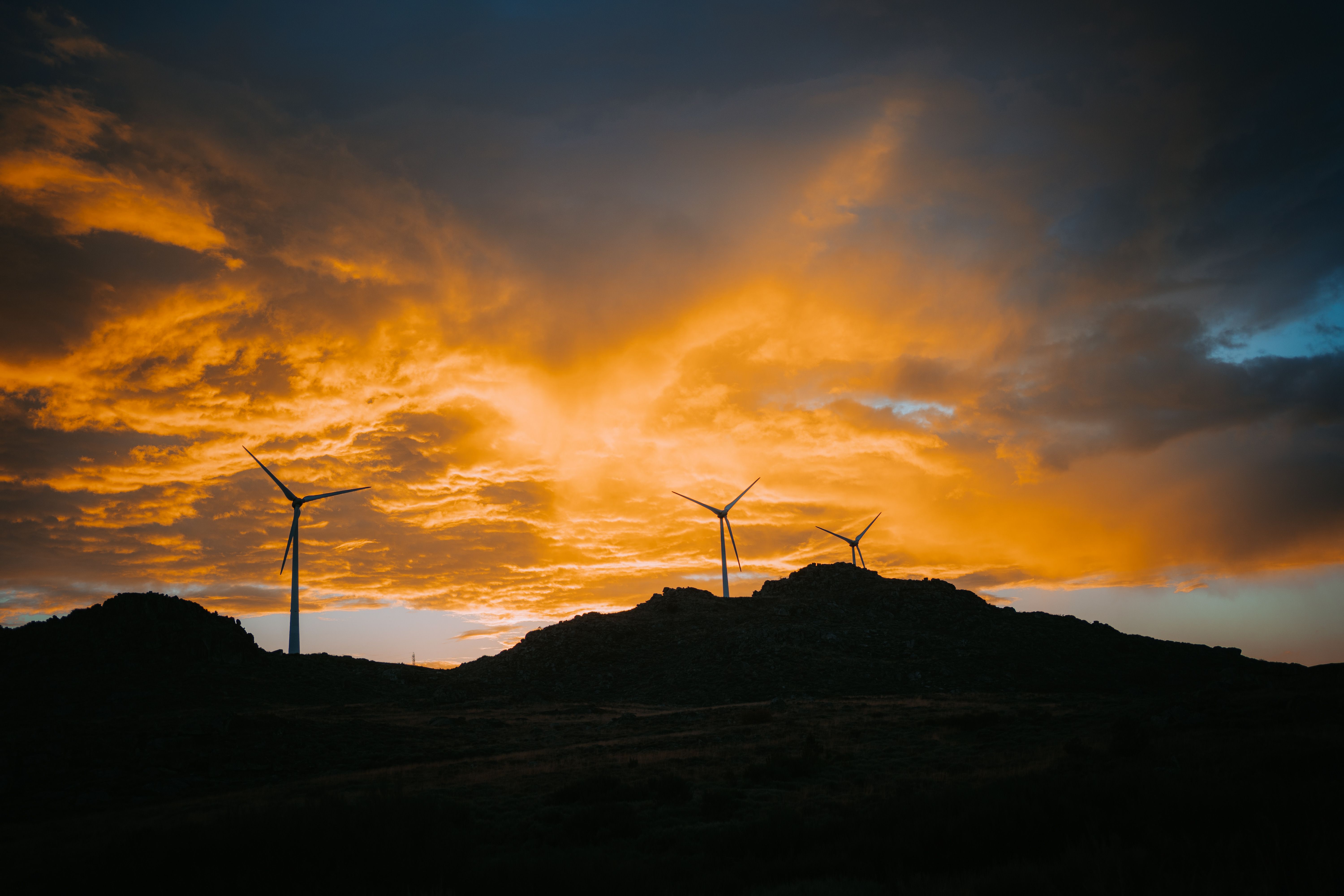 Wind turbines silhouetted against sunset sky · Free Stock Photo