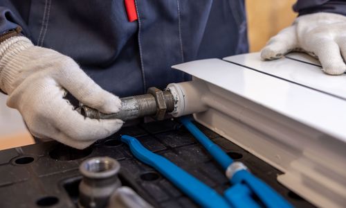 Plumber installing a radiator pipe