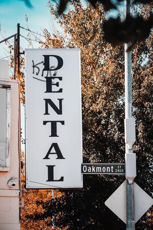 Free Close-up of a dental office sign on Oakmont Street, surrounded by autumn foliage. Stock Photo