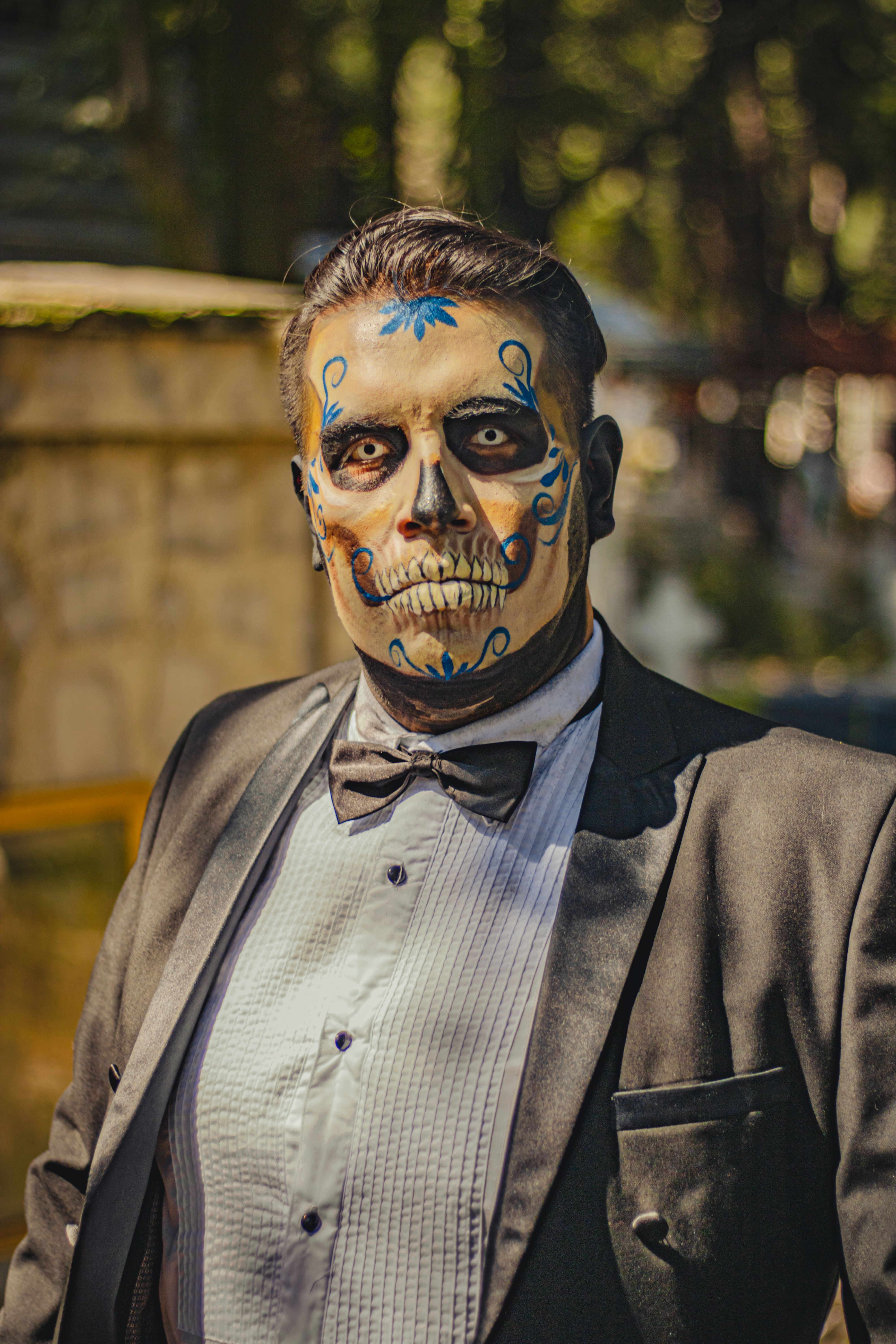 A man in Catrin makeup and formal attire celebrating Day of the Dead in Mexico City.