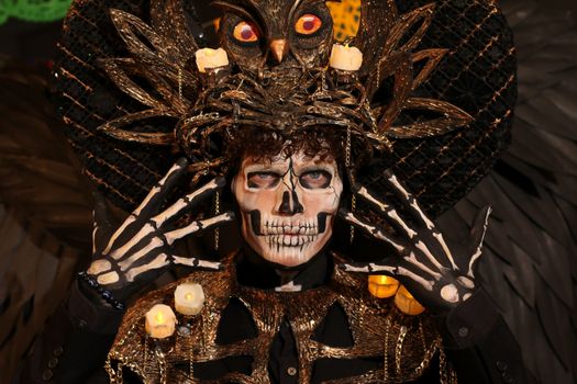 Intricate Halloween costume featuring skeletal makeup and ornate headdress with candles