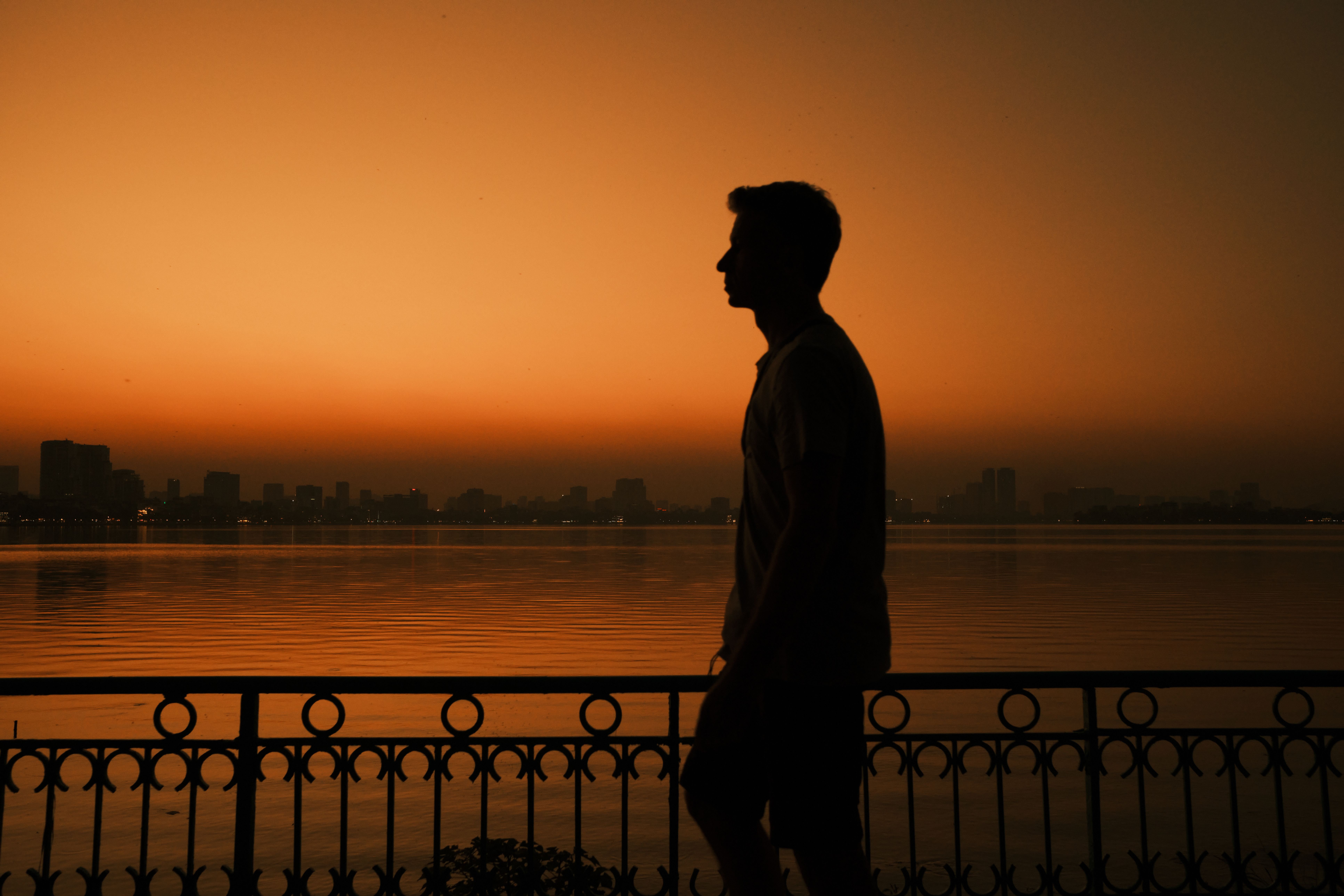 Silhouette of Man at Sunset over Hanoi's West Lake · Free Stock Photo