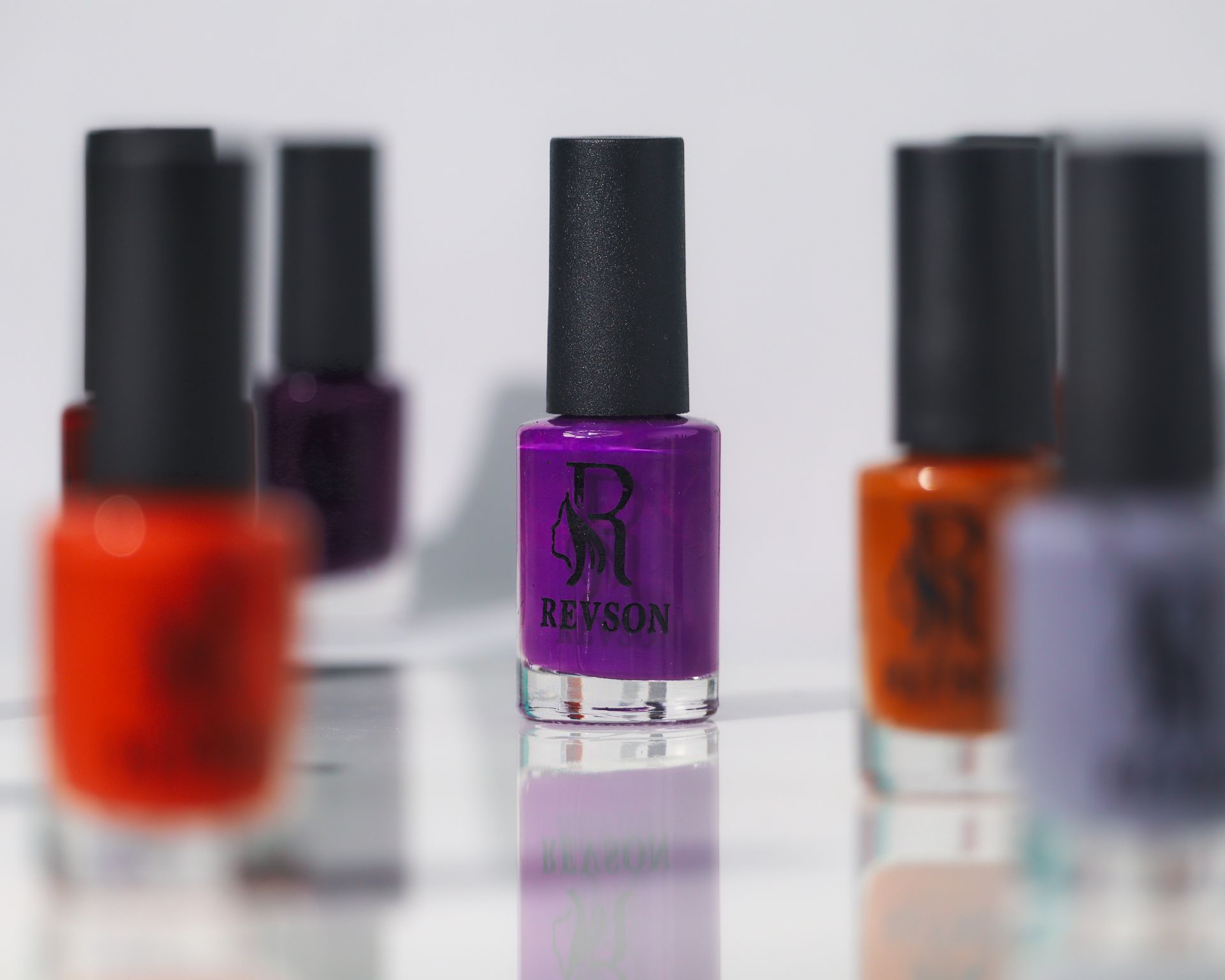 Vivid image showcasing various nail polish bottles with a focus on a purple shade.