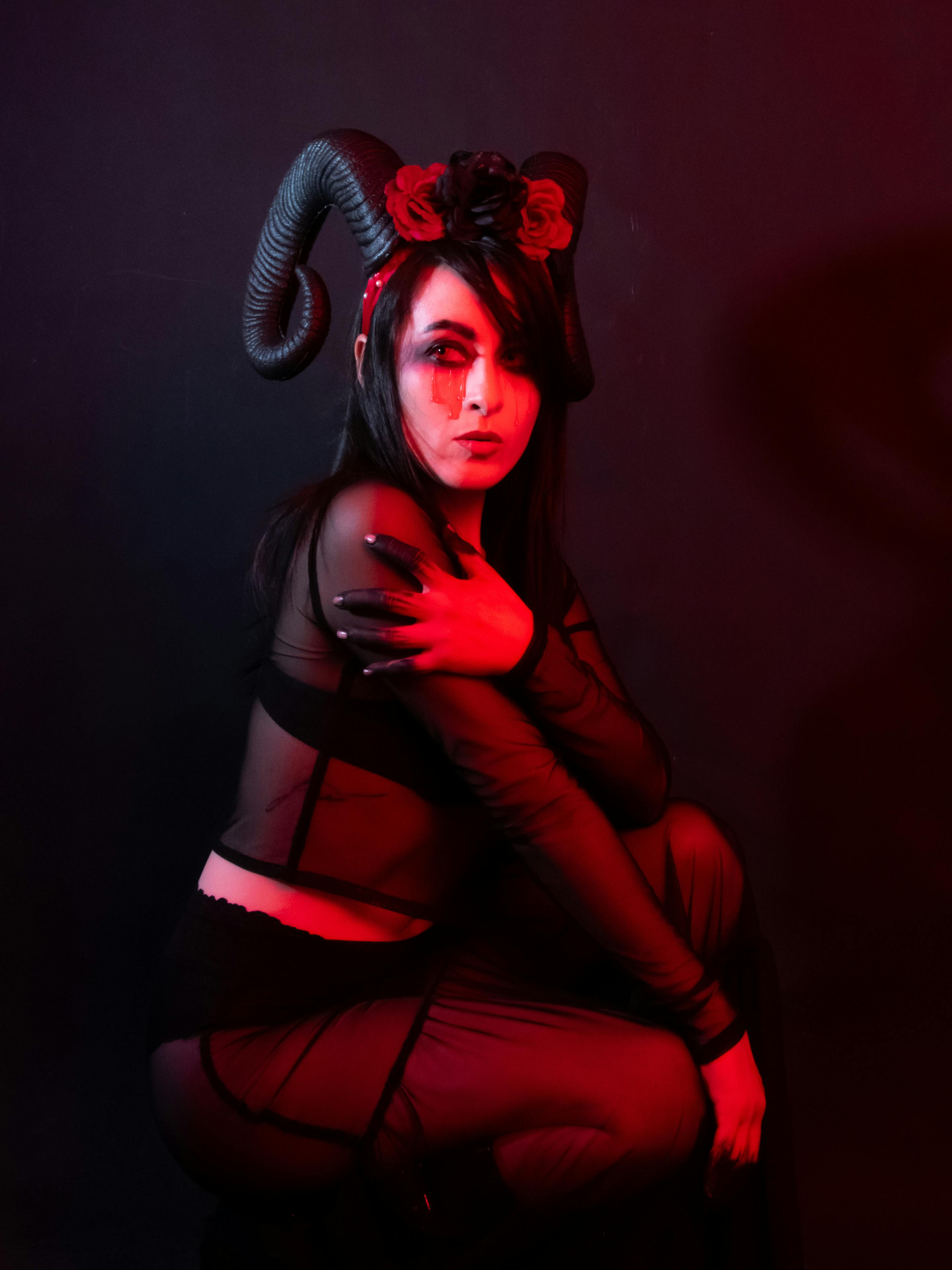 grátis Um retrato impressionante mostrando uma fantasia de demônio com iluminação vermelha, capturando uma atmosfera de Halloween. Foto profissional