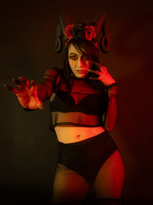 Free Striking portrait of a woman in a demon costume with horns in dramatic red and black light. Stock Photo