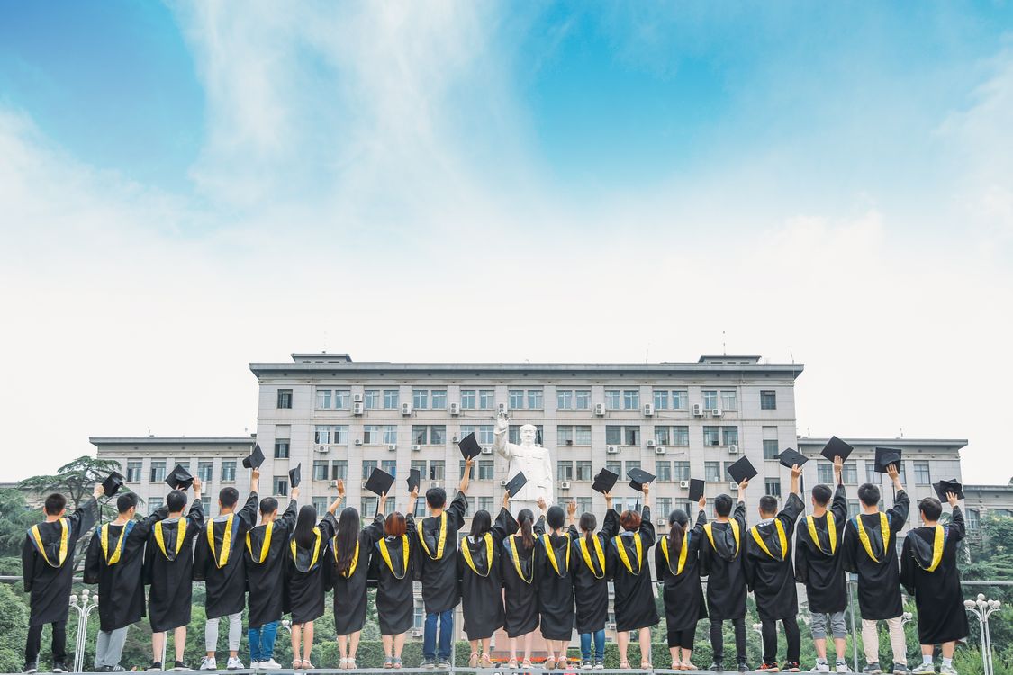 Graduates celebrating by throwing caps in the air at university commencement