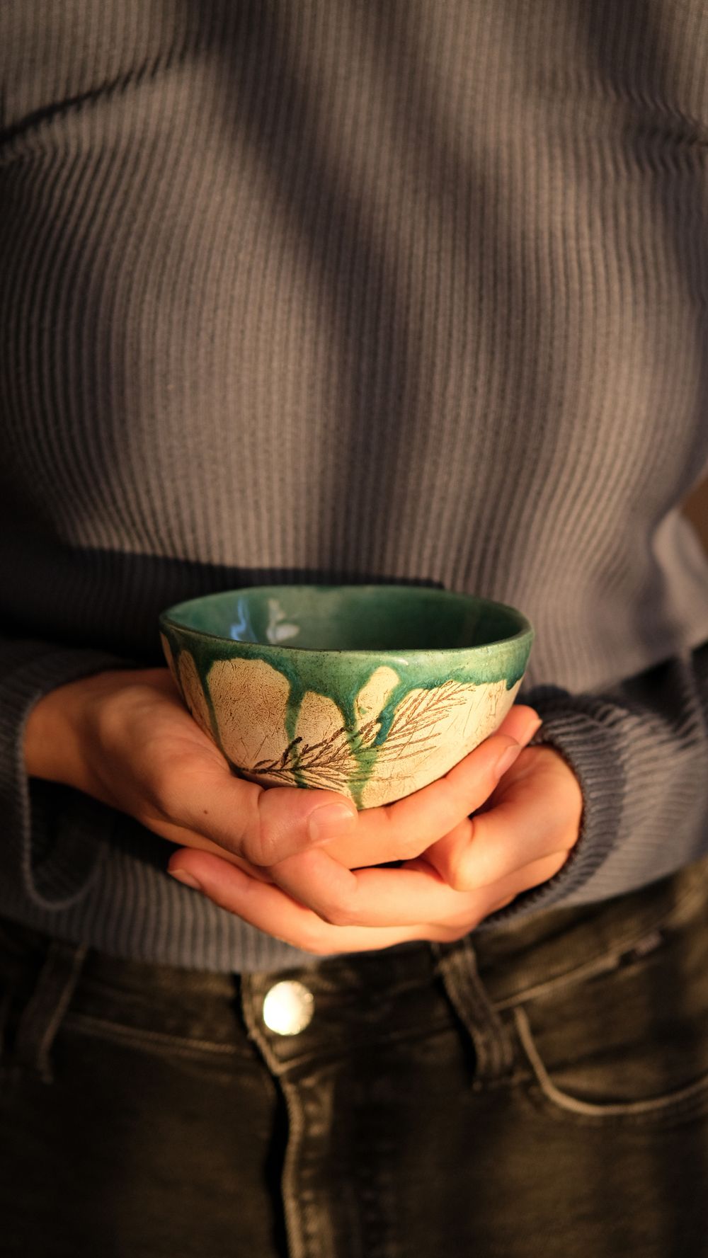 Hands holding a finished handmade bowl