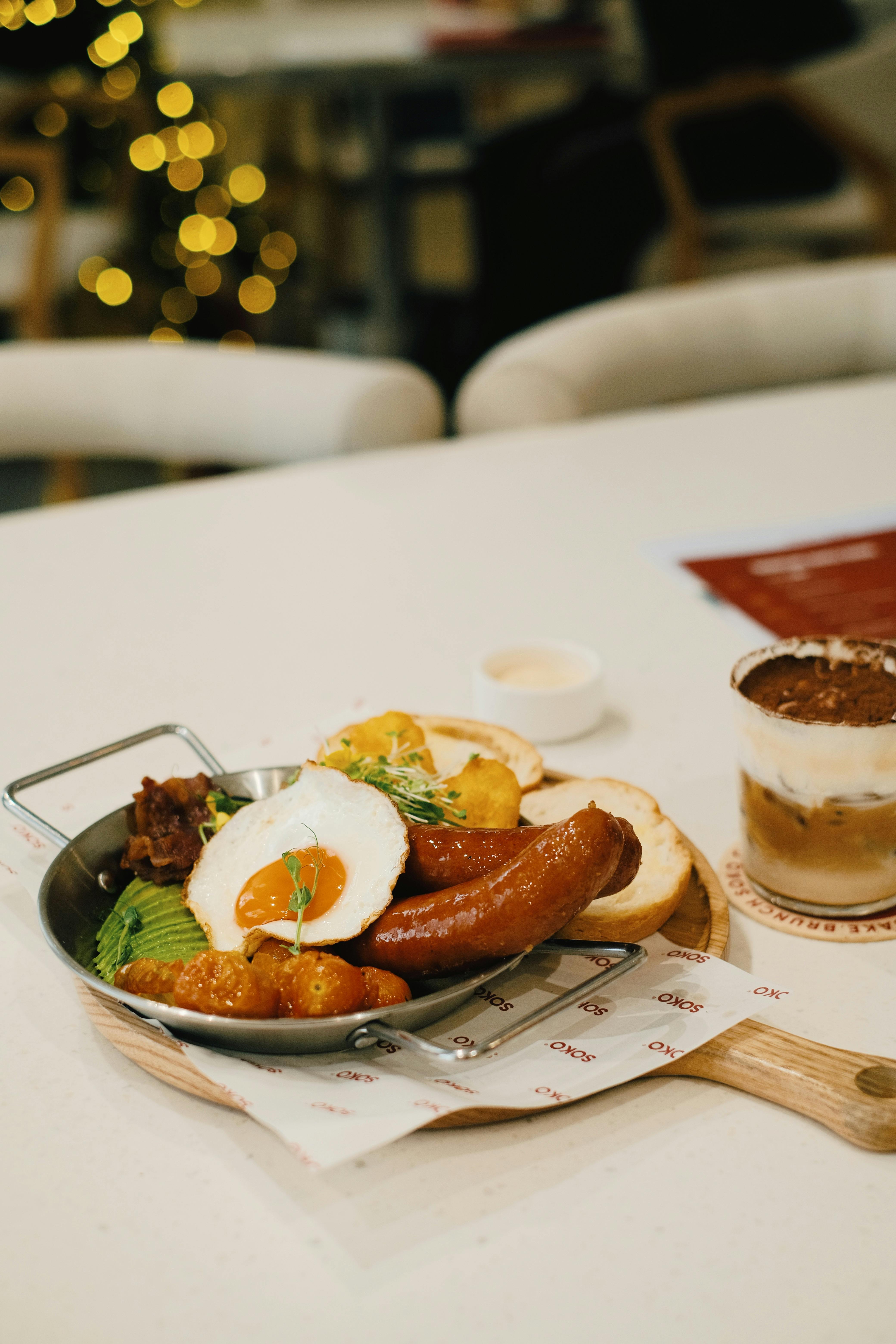 A tempting breakfast plate with sausages, fried egg, and coffee perfect for brunch.