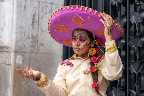Free A woman in Catrina makeup with a floral sombrero in Mexico City, showcasing Mexican culture. Stock Photo