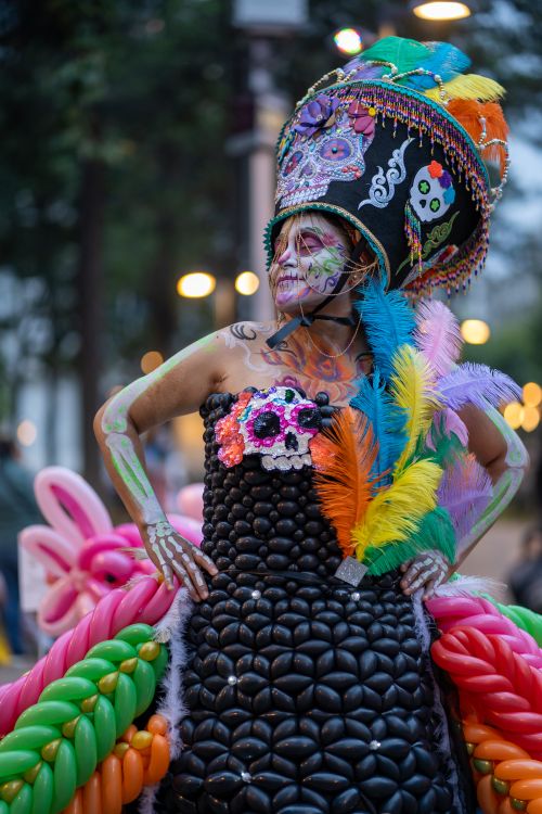 Free Colorful Day of the Dead costume with makeup and feathered headdress in Mexico City street. Stock Photo