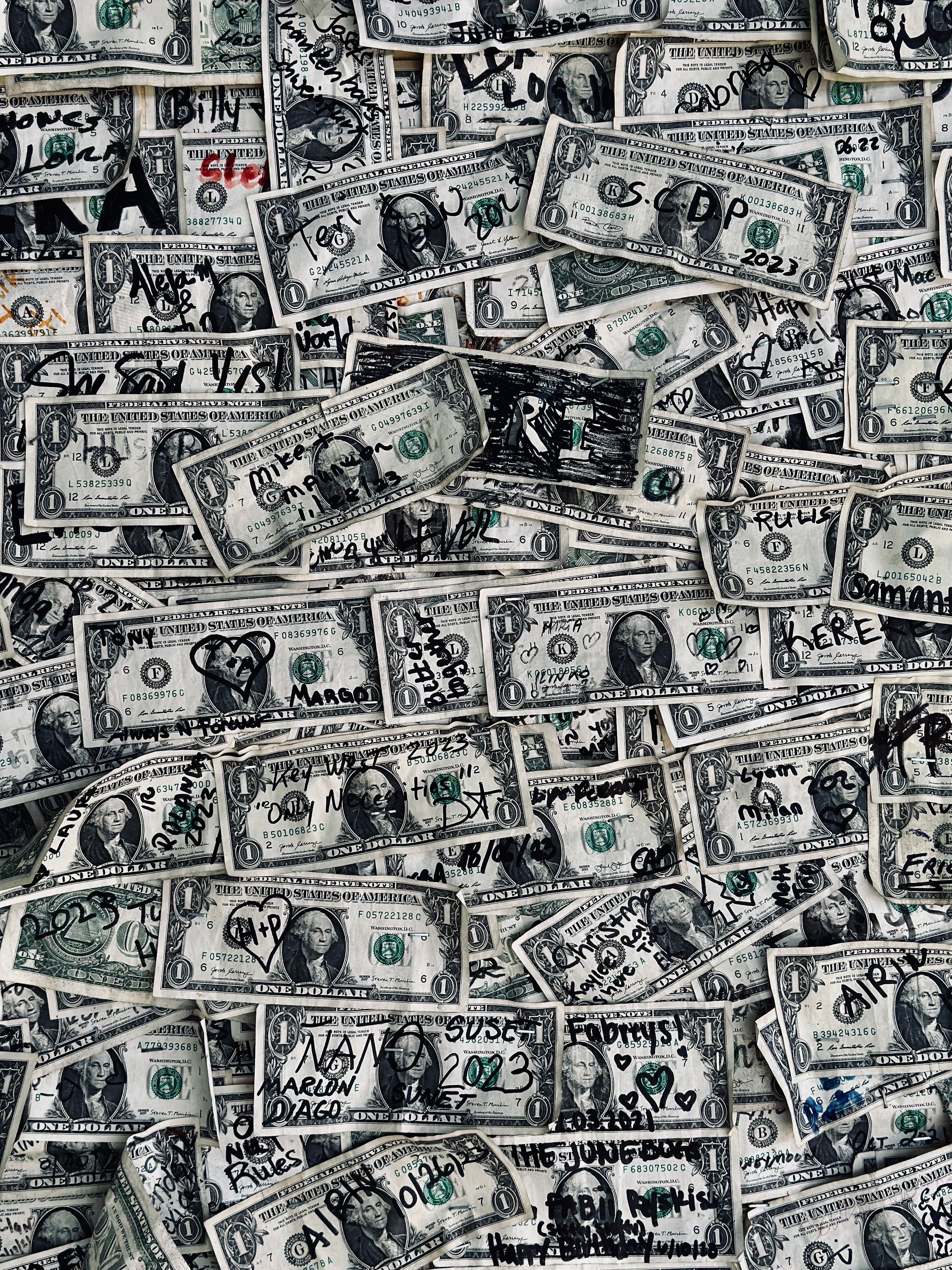 A collection of US dollar bills covered with handwriting and drawings in Key West.