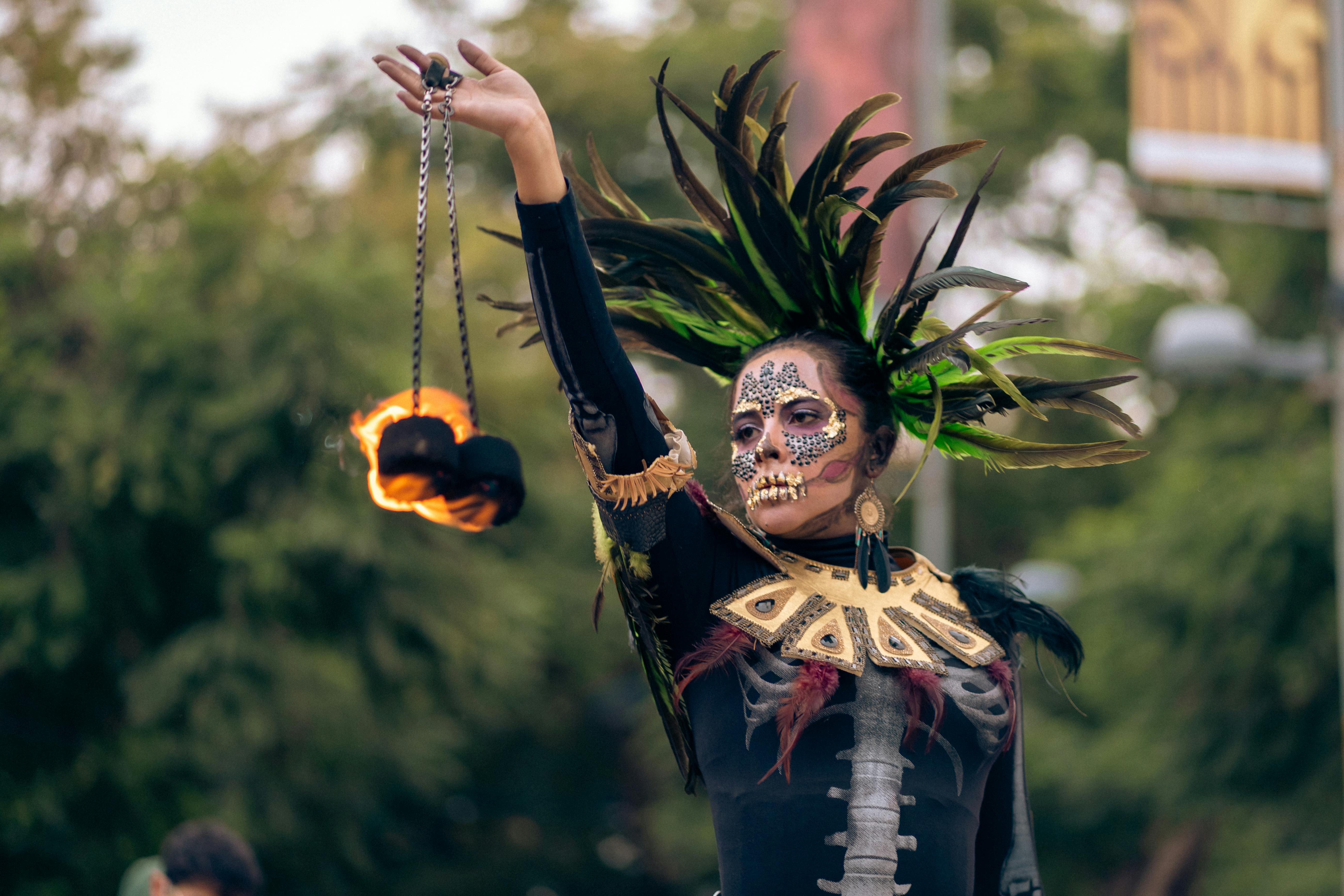 Colorful Catrina performer with feather headdress in Mexico City, embracing Mexican culture.