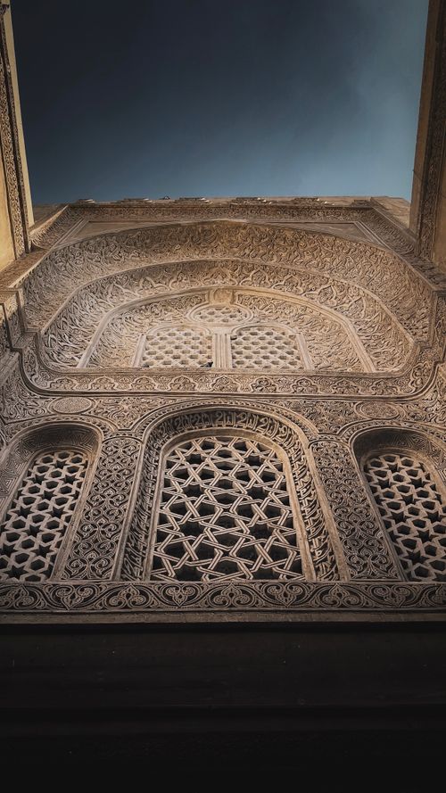 Free Upward view of detailed ornate facade with lattice designs against blue sky. Stock Photo