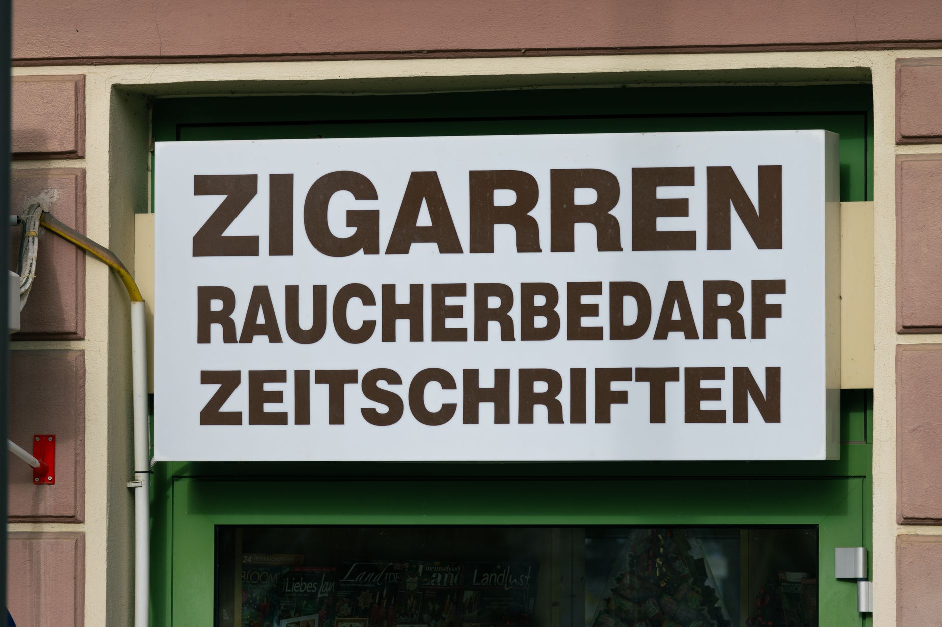 Shop sign in Mürzzuschlag, Austria advertising cigars, smoking supplies, and magazines.