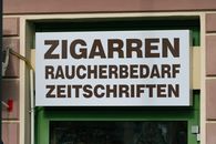 Shop sign in Mürzzuschlag, Austria advertising cigars, smoking supplies, and magazines.