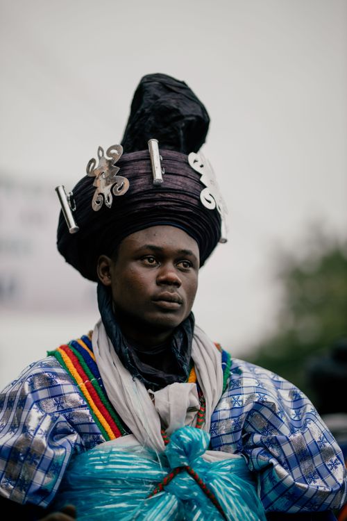 Free A portrait of a man in colorful traditional African attire with decorative headpiece. Stock Photo