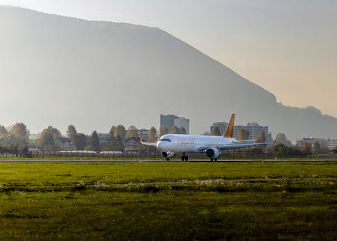 Commercial airplane on a runway against a scenic mountain landscape in Sarajevo.