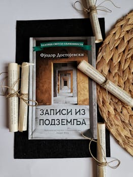 Dostoevsky's book styled with scrolls on a woven placemat and dark fabric.