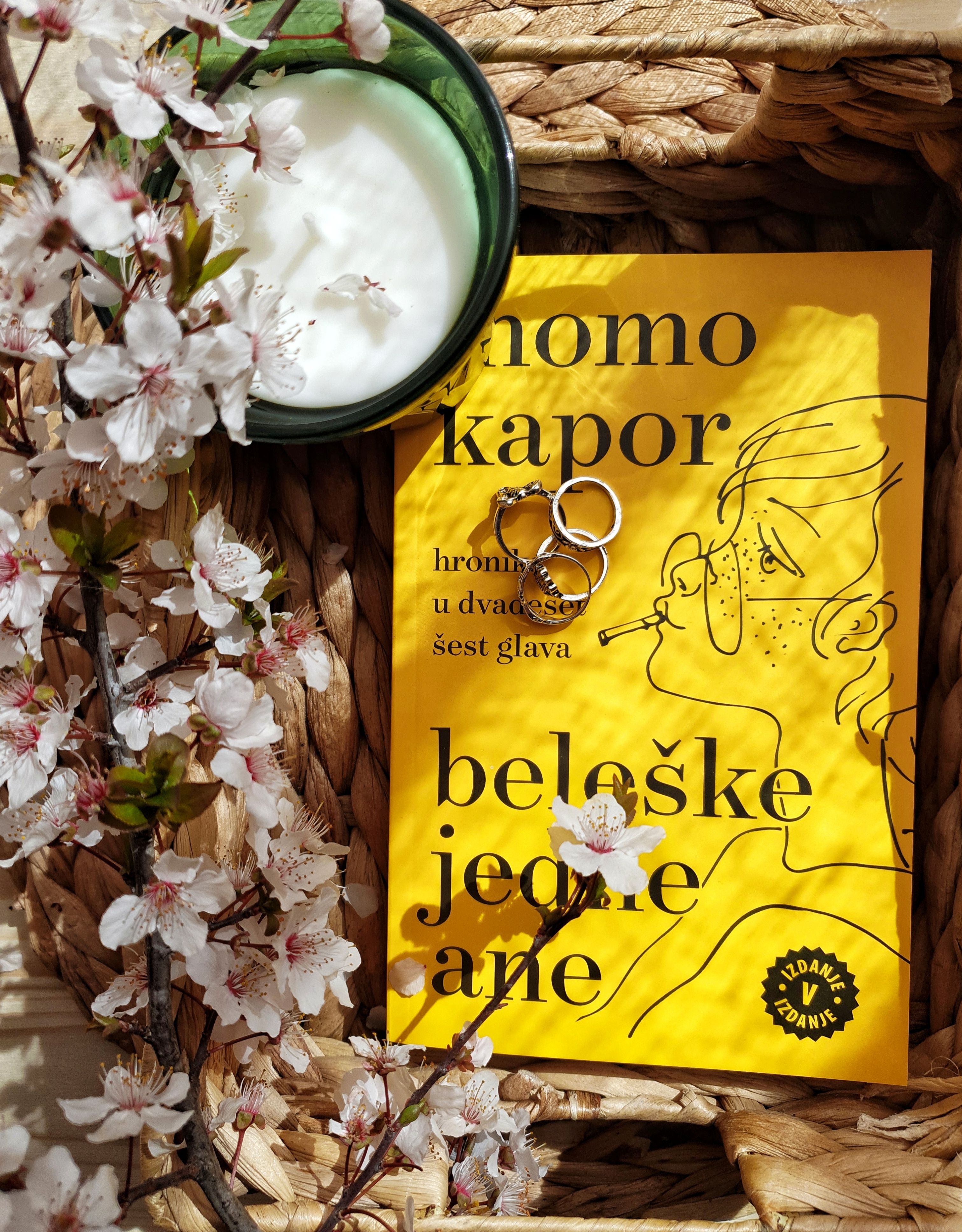 Serbian book with cherry blossoms and a candle in warm lighting.