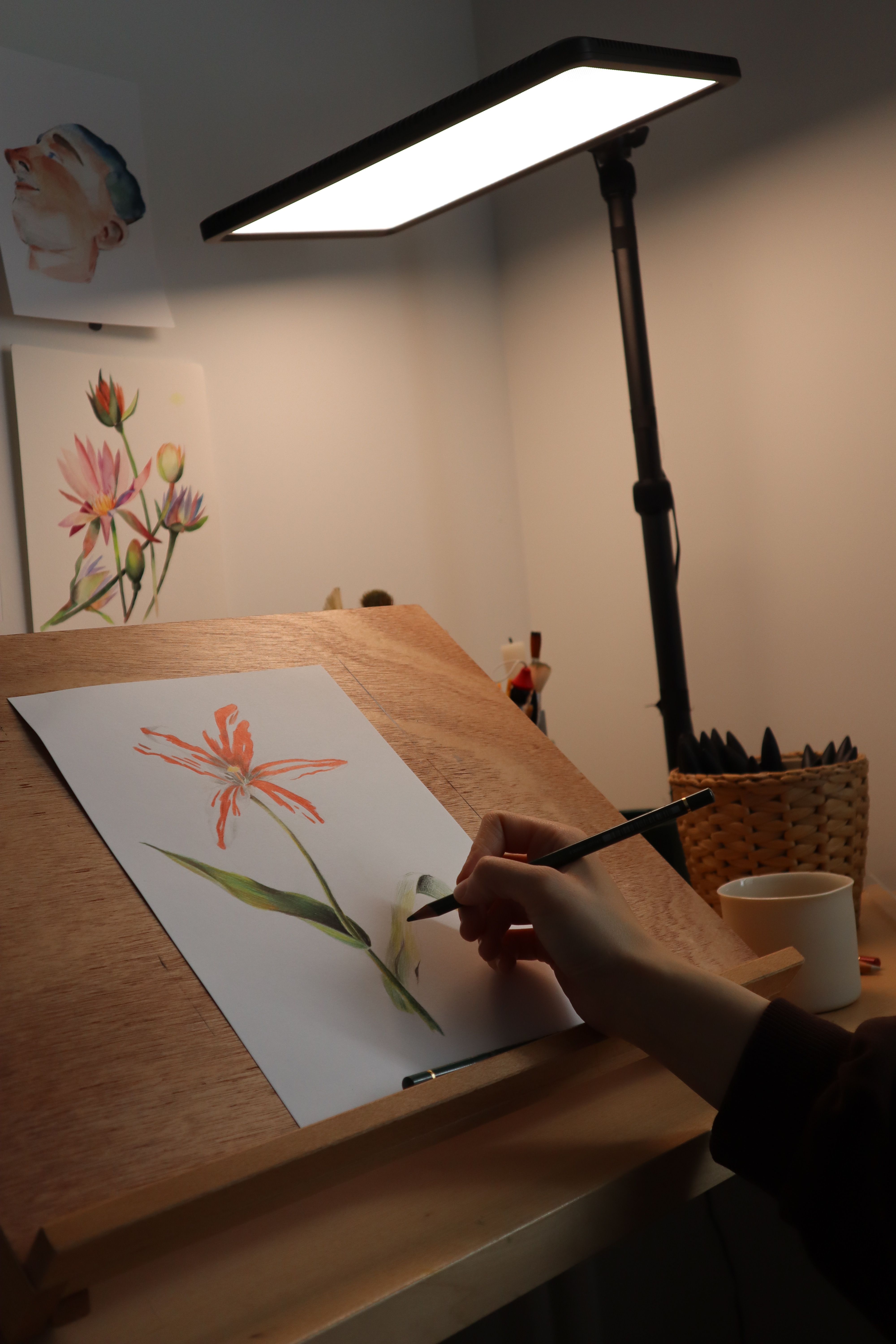 Artist Painting Flower at Desk Under Lamp