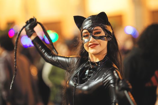 Woman in a black cat costume smiling at Arequipa festival. Perfect for Halloween and costume parade themes.