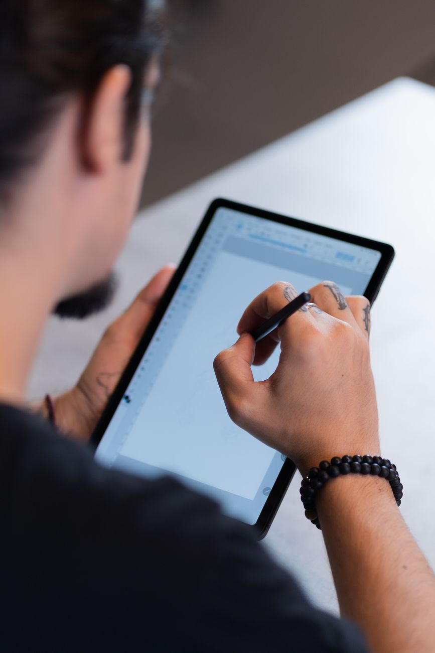 hand holding a tablet showing a touchscreen interface
