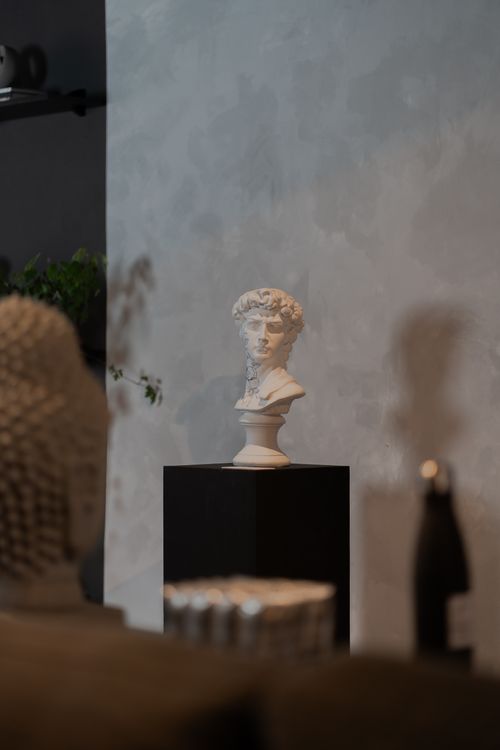 Free Stylish indoor scene featuring a classic bust statue on a pedestal. Stock Photo