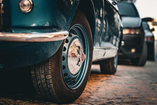 Close-up shot of a vintage car wheel in an urban setting, showcasing classic automotive design.