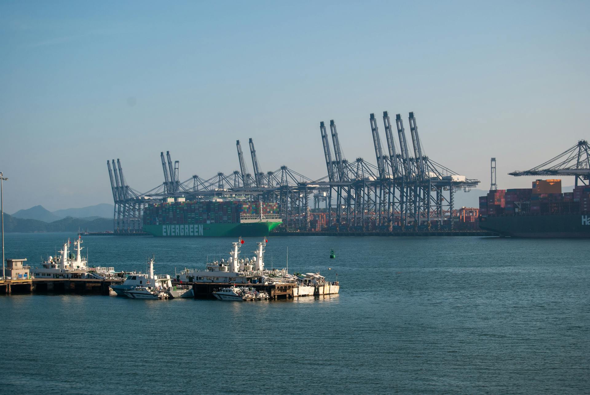 A vibrant view of container ships and cranes in a bustling marine cargo port.