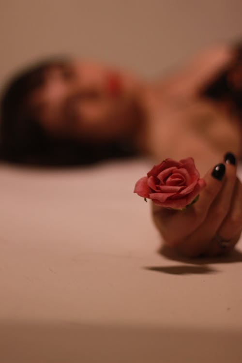 Женщина, держащая цветок розы