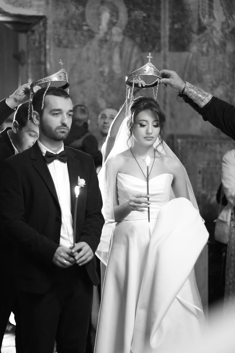 Black and white photo of a traditional wedding ceremony with priest and guests.