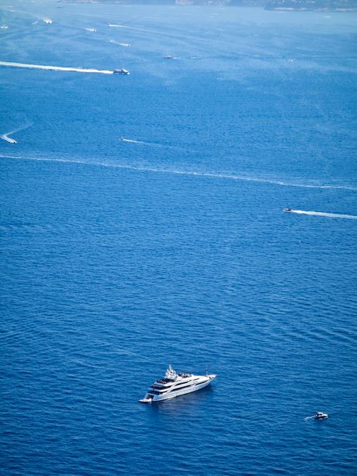 Free Aerial view of a luxury yacht cruising the blue waters near Capri, Italy. Stock Photo