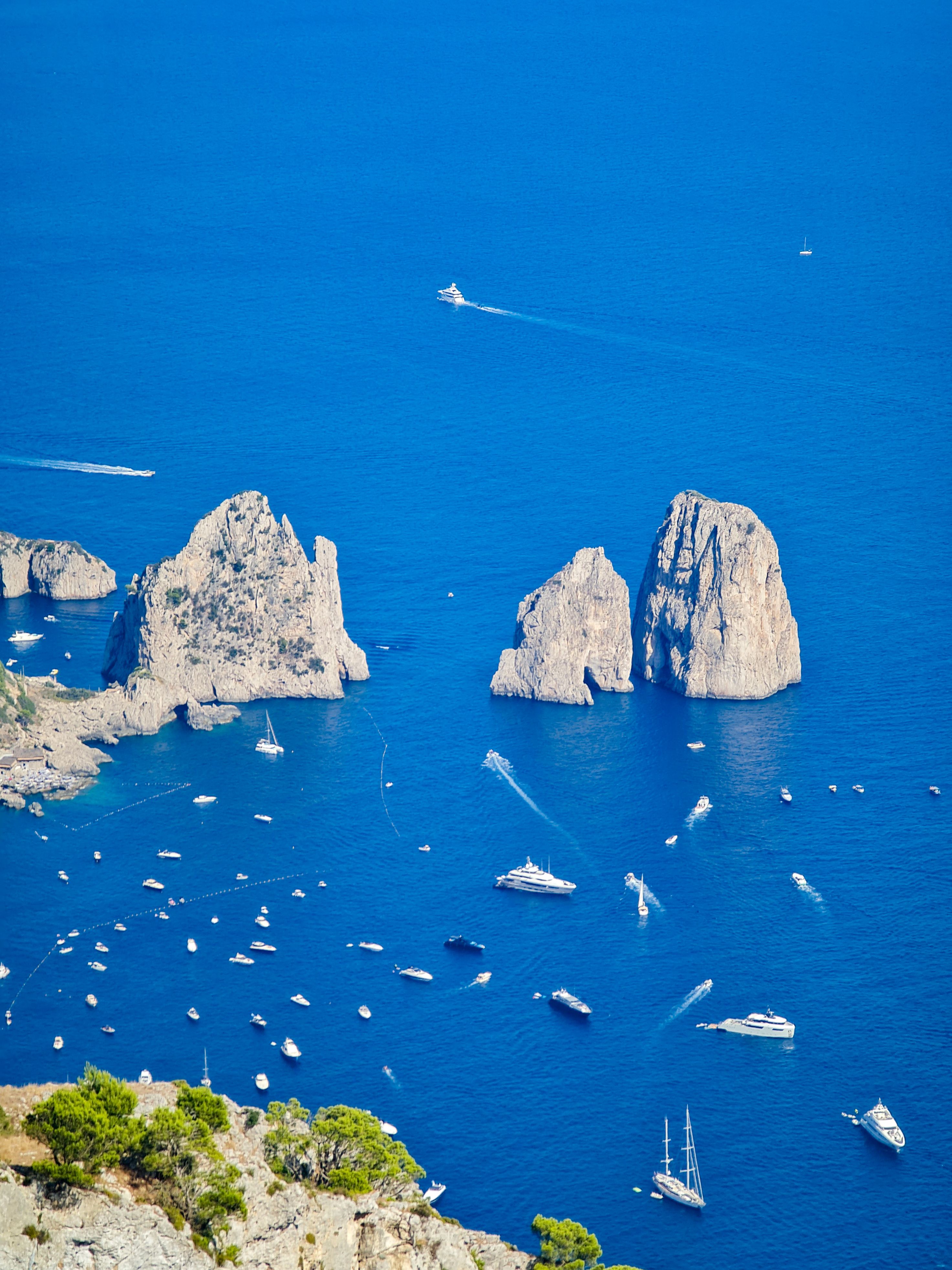 Excursie în Capri — vedere aeriană asupra stâncilor Faraglioni și apelor turcoaz