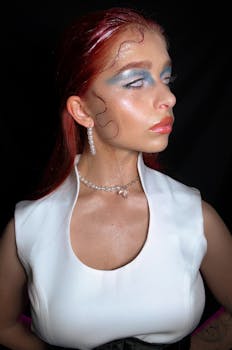 Stylish portrait of a woman with bold makeup and pearl jewelry, exuding elegance.