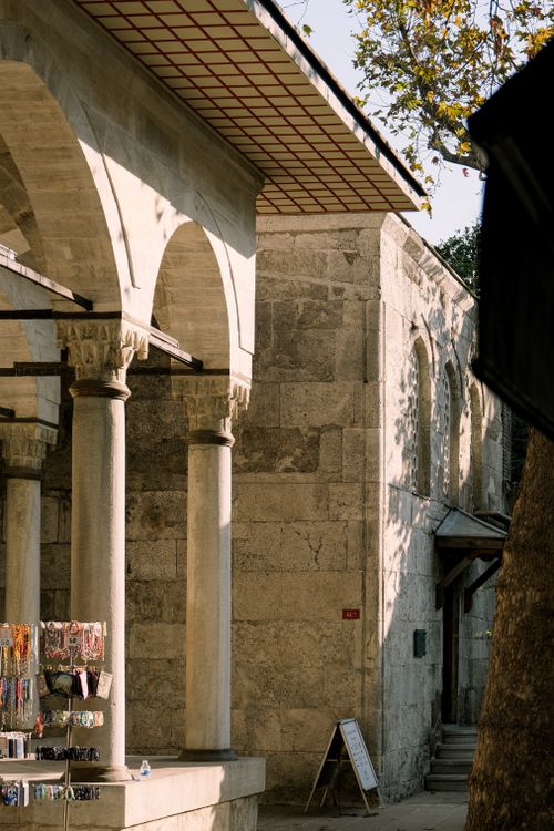 Free Sunlit historic stone building with arched structures and elegant columns, evoking a sense of classic architecture. Stock Photo