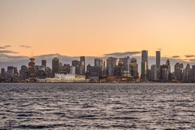 Downtown Vancouver is the city's bustling heart, encompassing vibrant neighborhoods like Yaletown, West End, and Coal Harbour. The image might showcase the sleek skyscrapers of Coal Harbour set against the backdrop of the shimmering Burrard Inlet and Stanley Park. Yaletown could be represented by its chic waterfront vibe, historic redbrick buildings, and trendy restaurants, while the West End offers a mix of modern condos and charming heritage homes nestled near lush parks and the famous English Bay beaches. Together, these areas create a dynamic urban core with a perfect balance of natural beauty, luxury living, and vibrant culture.