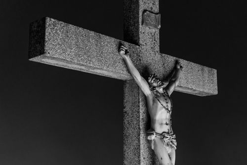 Free A powerful black and white image of a crucifix outdoors at night under clear sky. Stock Photo