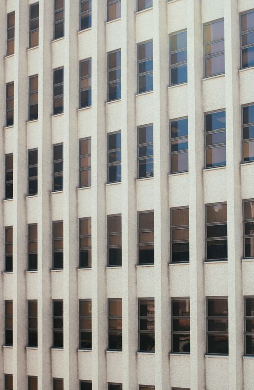 Free Close-up of a facade featuring repetitive geometric patterns and windows. Stock Photo