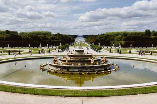 Free A stunning view of the Grand Fountain in the Versailles gardens, France, under a blue sky. Stock Photo
